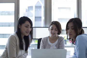 Obraz premium Three women are peek laptop screen