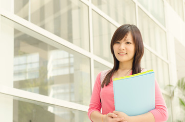 Obraz premium Young Asian college girl student at school campus