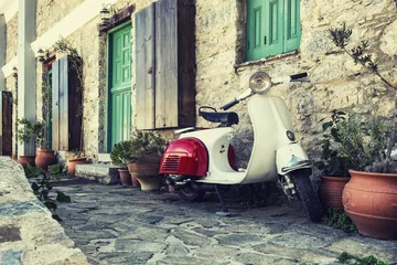 Fototapeten Alter Roller geparkt an der Wand in der leeren Straße von Karpathos, Griechenland. Nachbearbeitet mit Vintage-Filter. © seewhatmitchsee