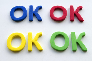 The word Okay which is written by colored letters on a light background 

