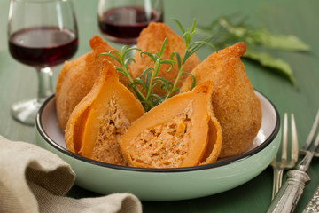 portuguese dish coxinhas de frango on plate on green wooden background
