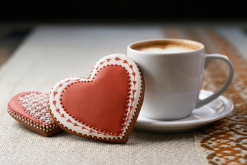 Coffee mania. Valentine’s day cup of frothed coffee with heart shaped cookies