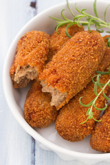 meat croquettes in white dish on blue wooden background