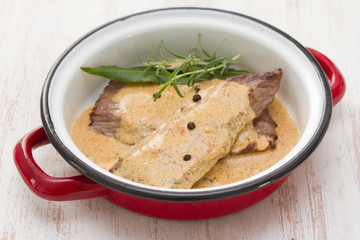 fried pork with pepper sauce in dish on white background