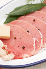 raw pork on dish with herbs,garlic