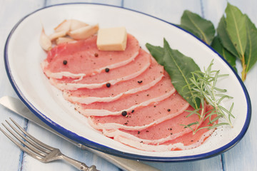 raw pork with bay leaf, black pepper and garlic on dish