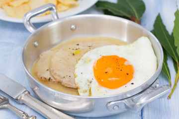 fried meat with sauce and fried egg in dish