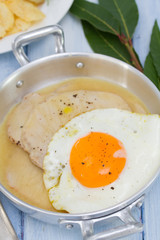 fried meat with sauce and fried egg in dish