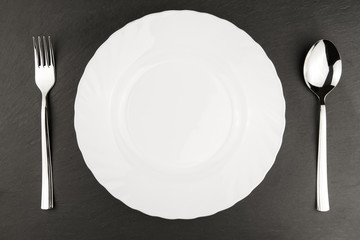 white plate on a black background. Table setting