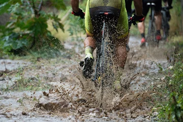 Crédence de cuisine en verre imprimé Vélo Mountain bikers driving in rain upstream creek