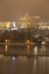 Fototapeta na wymiar Night romantic snowy Prague gothic Castle with Charles Bridge, Czech republic