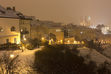 Night snowy foggy Prague City with gothic Castle, Czech republic