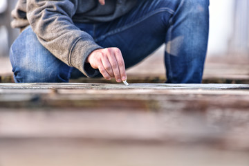 Fototapeta na wymiar Hand of a young man extinguishing cigarette on a old bridge. Con