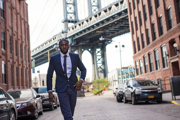 Young confident businessman portrait with Manhattan Bridge in the background.