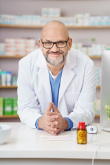 freundlich lächelnder apotheker im verkaufsraum