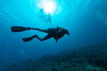 Fotobehang Female scuba diver silhouette underwater © Jag_cz
