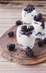 yogurt cup with blackberry on wooden table