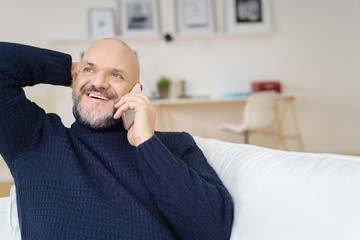 mann sitzt auf dem sofa und telefoniert
