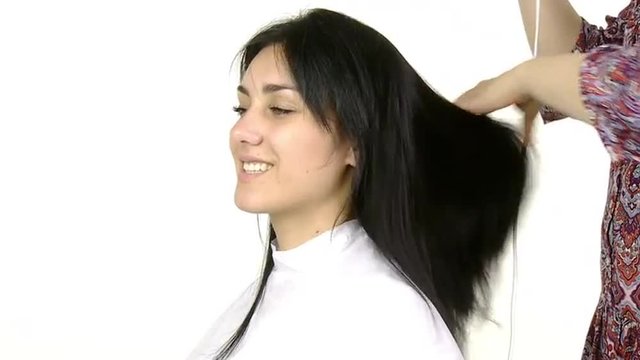 Woman at hairdresser getting long hair dryed with blowdryer isolated slow motion