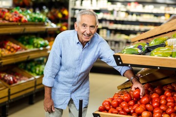 Senior man choosing tomato carefully