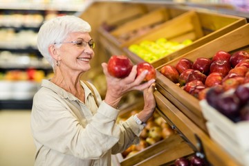 Senior woman picking out red apple