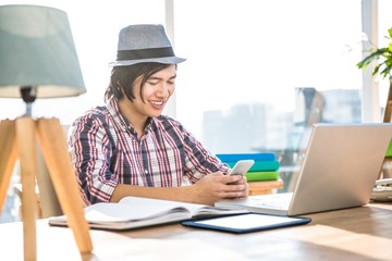 Smiling hipster businessman using smartphone 