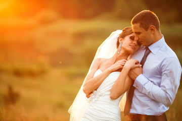 gentle couple is posing on the background beautiful sunset