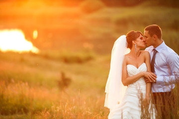 gentle couple is kissing on the background beautiful sunset