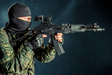Special forces soldier with rifle on dark background
