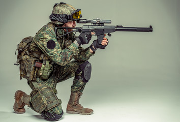 Special forces soldier with rifle on dark background
