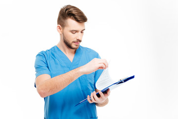 Male doctor reading checklist from clipboard
