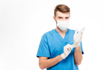 Male doctor putting on gloves
