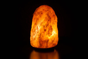 Salt lamp on black background