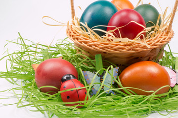 Easter eggs in wicker basket on white