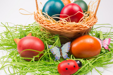 Easter eggs in wicker basket on white
