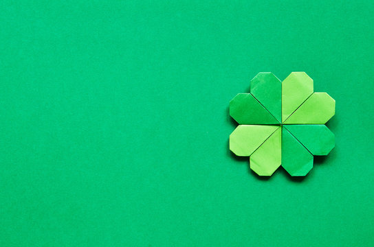 Green origami shamrock clover leaf paper background. St. Patrick's Day greeting postcard template. Space for copy, text, lettering.
