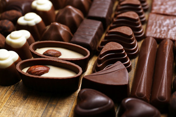 Delicious chocolate candies on wooden background