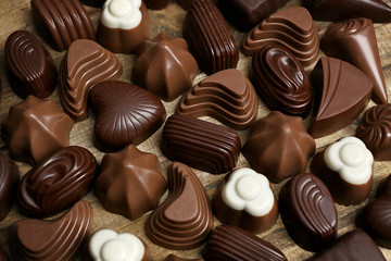 Assortment of delicious chocolate candies background, close up