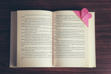Heart bookmark for book on wooden table closeup
