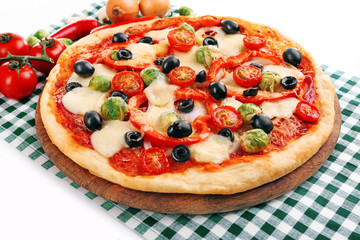 Delicious pizza with cheese and vegetables on green checkered napkin closeup