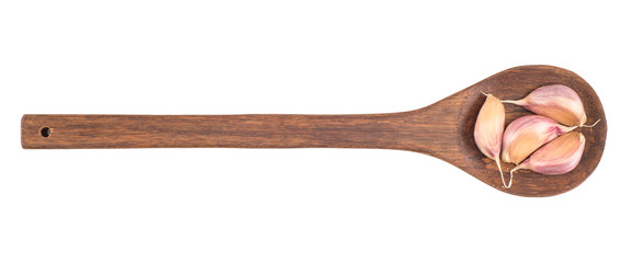 Garlic on wooden spoon isolated on white background