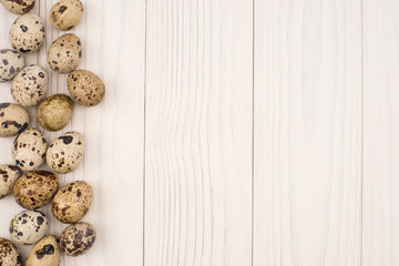 Quail eggs on wooden table top view