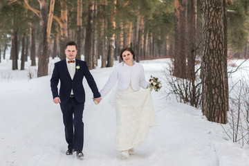 couple newlyweds walking in a winter forest