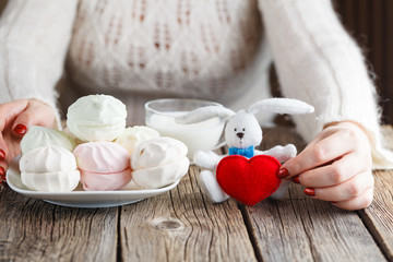 Woman offer red toy heart and eat sweets