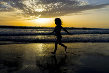 Little girl bathing on the beach at dusk