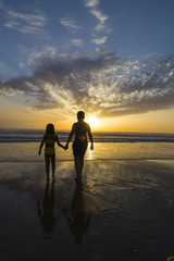Fototapeta premium Children bathing on the beach at dusk