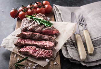Grilled beef steak with rosemary and salt on cutting board