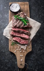 Papier Peint photo autocollant Steakhouse Steak de boeuf grillé au romarin et sel sur planche à découper