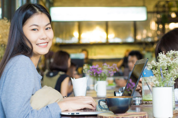 Beautiful asian woman using laptop inside coffee shop