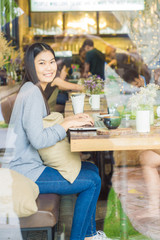 Beautiful asian woman using laptop inside coffee shop